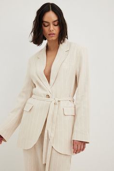 This blazer is belted and features a lapel neckline. It has long sleeves and shoulder pads. This blazer features a mock chest pocket, a button closure at the front, belt loops, a self tie waist belt and two flap pockets on the front. Blazer Beige, Future Fashion, Striped Blazer, Double Breasted Blazer, Short Coat, Business Attire, Na Kd, Cut And Style, Stripe Print