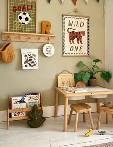 a child's playroom with toys and artwork on the wall, including a wooden table and chairs