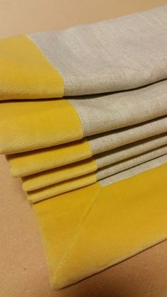 four yellow and white towels folded on top of each other, with one folded in the middle