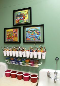 there are many cups and pencils in the holder on the wall next to the sink