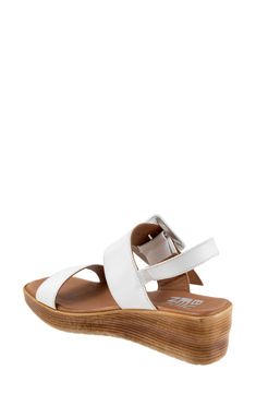 An oversized buckle accents the leather strap of an elegant square-toe sandal resting on a chunky wedge sole. 2 1/4" heel Cushioned footbed Leather upper and lining/rubber sole Made in Turkey Modern Wedge Sandals With Buckle For The Beach, Modern Beach Wedge Sandals With Buckle, Modern Beach Wedge Sandals With Buckle Closure, Modern Slingback Sandals With Wedge Heel, Vacation Slingback Wedge Sandals With Buckle Closure, White Slingback Sandals With Leather Footbed And Ankle Strap, White Wedge Heel Sandals With Leather Footbed, White Ankle Strap Slingback Sandals With Leather Footbed, White Leather Slingback Wedge Sandals