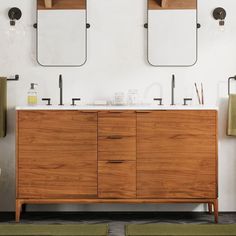 a bathroom vanity with two mirrors above it