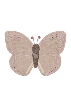 a white butterfly with brown spots on it's wings, sitting on a white surface