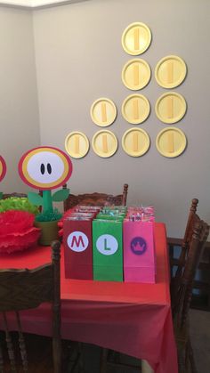 the table is set up with mario birthday party decorations and paper bags for each child's name