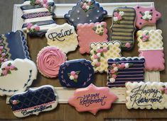 decorated cookies are arranged on a table with happy birthday signs and flowers in the middle