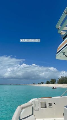 the back end of a boat in clear blue water with white sand and palm trees