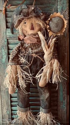 an old scarecrow doll hanging on a door