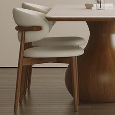 a dining table with two chairs and a vase on it, in front of a white wall