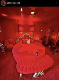 a room with red walls and furniture in the center, including a round bed that is shaped like an elephant