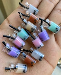 a person is holding several small beads in their hand, each with different colors and shapes