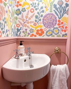 a white sink sitting under a bathroom mirror next to a wall mounted faucet