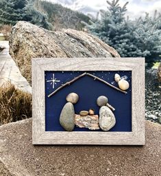 a wooden frame with some rocks in the shape of a house and two birds on it