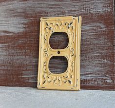 a light switch cover sitting on top of a wooden floor