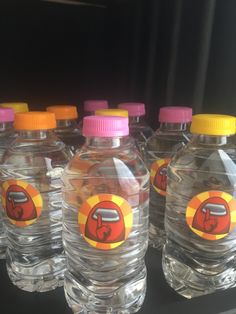 several plastic water bottles are lined up on the shelf in front of another bottle with an orange and pink top