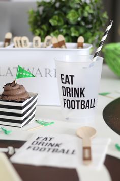 a cupcake sitting on top of a table next to a drink in a paper cup