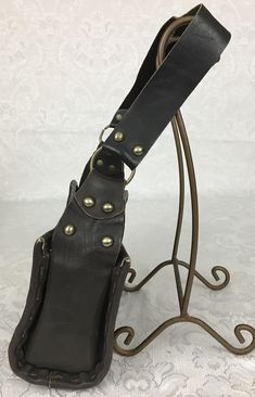 "Here we have a vintage brown leather footed Purse with a wide strap, metal studs and large buckle. This has a great retro look. This is in very nice condition considering its age. I noticed some light scratches but no ther problems. It measures: Height - 6\" Width - 9 3/4\" Depth - 4 1/4\" Strap Drop - 11 1/4\" I try my best to give accurate descriptions, although I am no expert, plus I'm human and sometimes I might miss a flaw. I always provide high resolution photos and consider them to be pa Brown Leather Bags With Rivets, Steampunk Leather Bag With Belt Loops, Brown Leather Purse, Studded Leather, Boho Bag, High Resolution Photos, Wide Straps, Retro Look, Vintage Brown