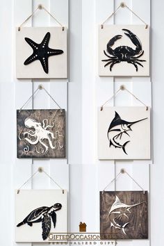 four wooden signs hanging on the wall with sea animals and starfishs painted on them