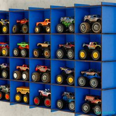 there are many toy trucks in the blue bins on the wall and one is yellow