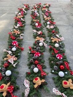 christmas wreaths are lined up on the sidewalk