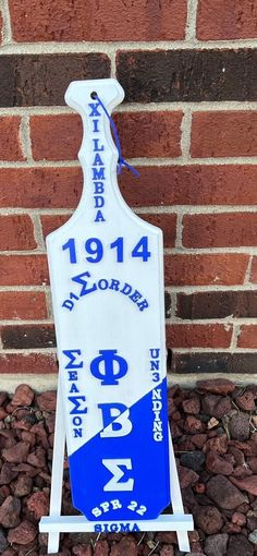 a blue and white sign sitting next to a brick wall