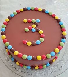 a chocolate cake with colorful candies and the number eight on it's side