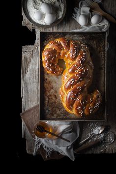 two pretzels sitting on top of a baking sheet next to eggs and butter