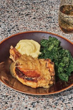 a plate with meat, mashed potatoes and greens