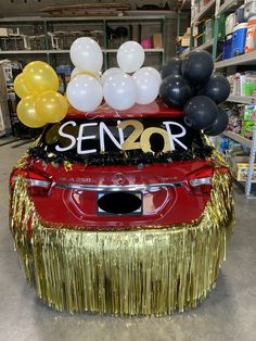 a car decorated with balloons and streamers for a senior year party in a store