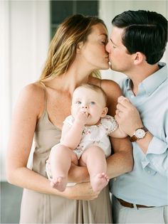 a man kissing a woman while holding a baby