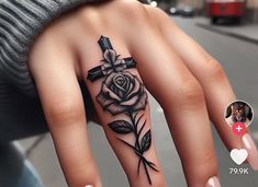 a woman's hand with a cross and rose tattoo on it