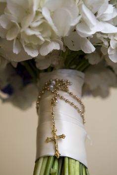 a white vase with flowers and a cross on it