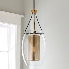 a light fixture hanging from the ceiling in a room with white walls and window sill