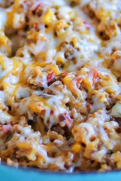 a casserole dish with cheese, meat and other toppings in a blue bowl