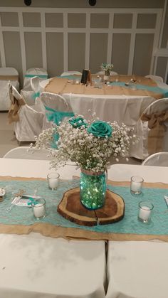 a vase with baby's breath sits on a table set for a wedding reception