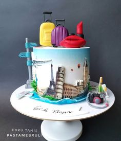 a cake decorated with luggage and the eiffel tower