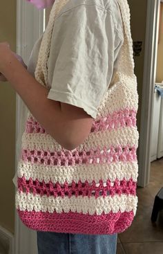 a little boy holding a crocheted bag in his hands