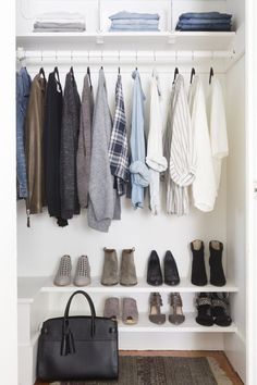 a white closet with shoes and handbags hanging on the wall next to an open door