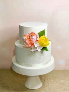 a three tiered white cake with flowers on top