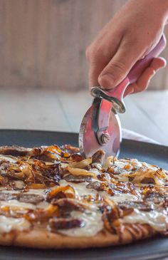 someone is cutting into a pizza on a pan