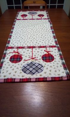 the table runner is made from plaid fabric and has an apple design on it, along with two red apples