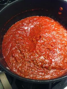 a pan filled with sauce sitting on top of a stove