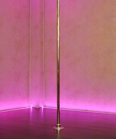 a floor lamp in front of a pink wall