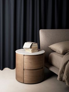 a bed with a book on top of it next to a nightstand