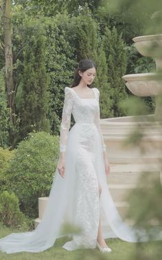 a woman in a white wedding dress standing outside