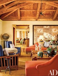 a living room filled with lots of furniture and wooden ceiling beams on top of a hard wood floor