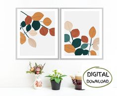 two framed art prints on the wall above a table with flowers and coffee mugs