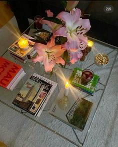 a glass table topped with magazines and flowers