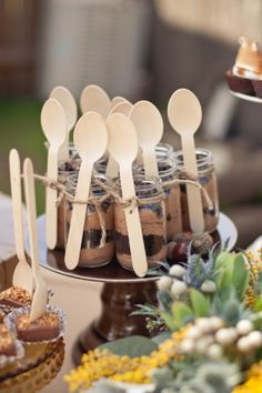 a bunch of wooden spoons sitting on top of a table next to some food