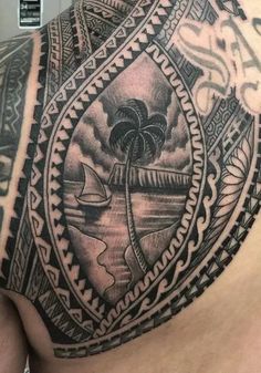 the back of a man's shoulder with an island and palm tree on it