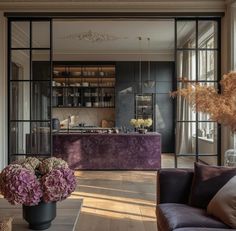 a living room filled with lots of furniture and flowers on top of a wooden floor